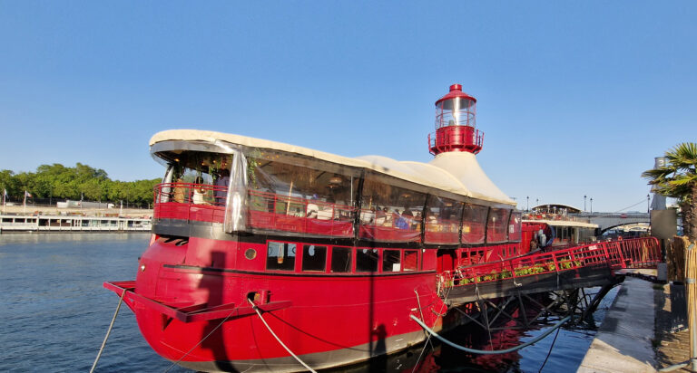 Le Bateau Phare, a red boat topped by its lighthouse, moored on the Seine in Paris 13th