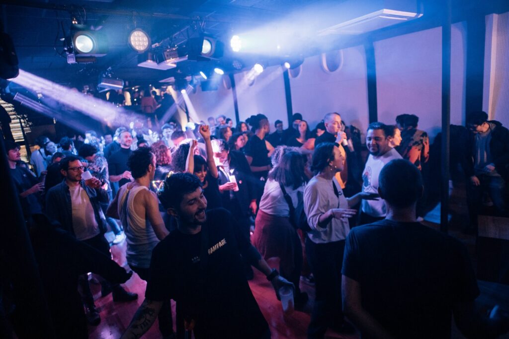 Audience dancing under the stage lights in the Cale of Le Bateau Phare, Paris 13th